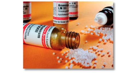 Abbildung einer kleinen Flasche mit Globuli daneben.